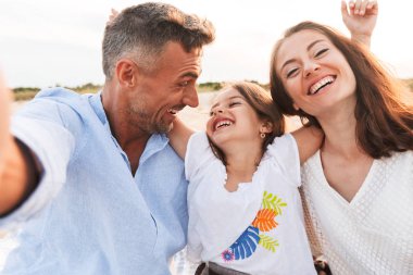 Genç neşeli görüntüsünü aile açık havada beach almak bir selfie kamera tarafından heyecanlıyım..