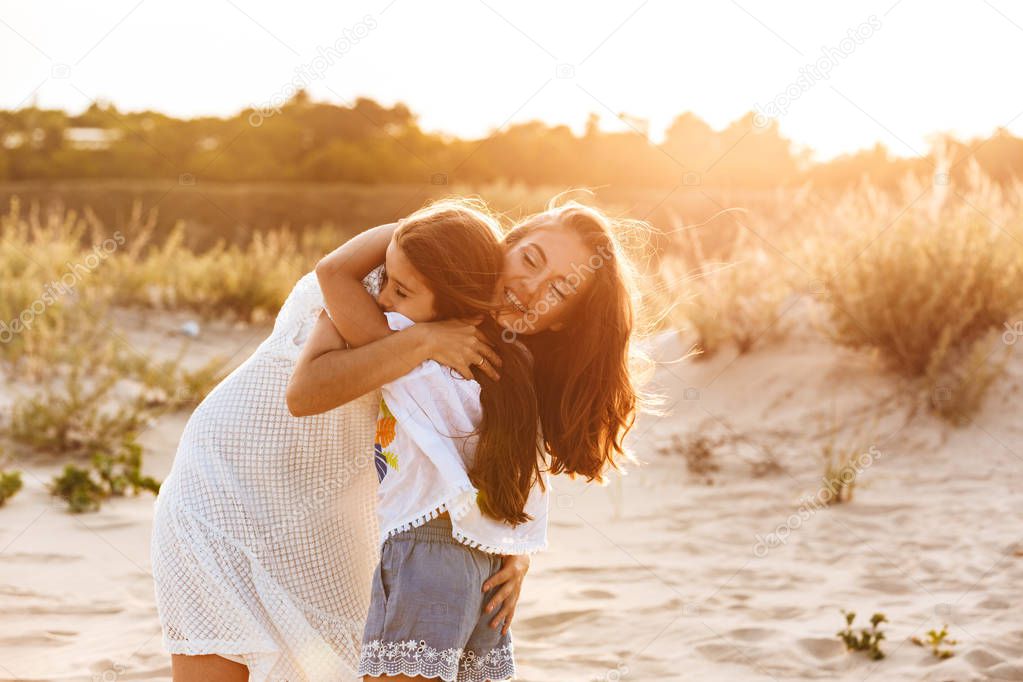 Photo of young cute happy family having fun together outdoors at the beach.