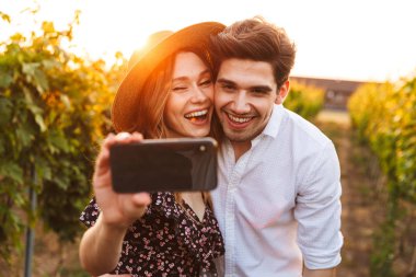 Genç şirin mutlu sevgi dolu çift açık havada fotoğrafını çekin bir selfie cep telefonuyla.