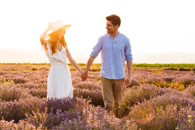 Romantik genç adam ve birlikte yürüyen kadın fotoğrafı açık lavanta alanındaki