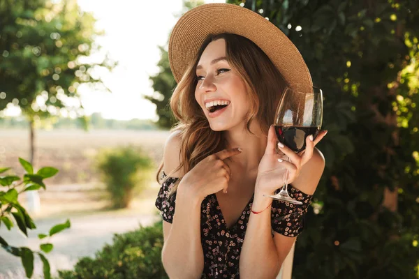 Imagen Joven Risueño Sentada Cafetería Parque Sosteniendo Vaso Bebiendo Vino — Foto de Stock