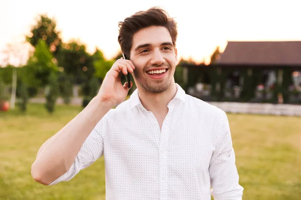 Image Joyful Young Man Wearing White Shirt Smiling Talking Black — Stock Photo, Image