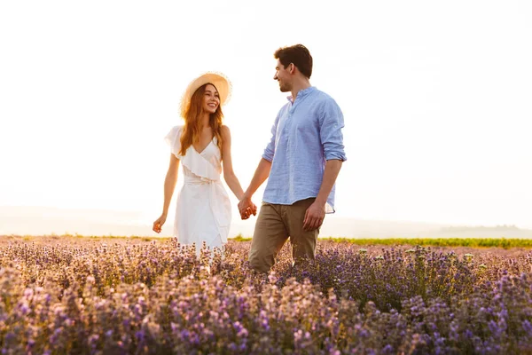 可爱的年轻夫妇牵手在薰衣草领域 — 图库照片