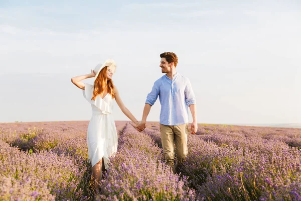 Fröhliches Junges Paar Das Sich Lavendelfeld Umarmt Händchen Hält Geht — Stockfoto