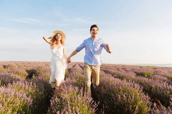 Feliz Joven Pareja Abrazándose Campo Lavanda Tomados Mano Corriendo — Foto de Stock