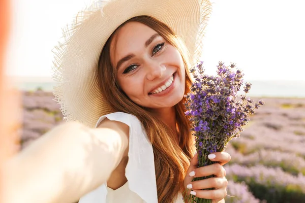 Schönes Junges Mädchen Mit Strohhut Hält Lavendelstrauß Auf Dem Feld — Stockfoto