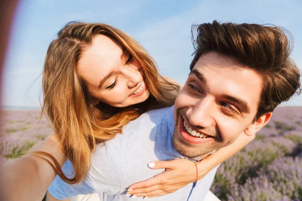 Bir Selfie Lavanta Alan Sırtına Alarak Mutlu Genç Çift Binmek — Stok fotoğraf