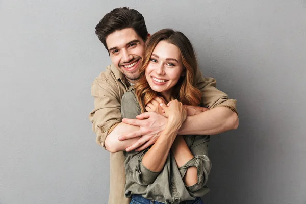 Preciosa Pareja Joven Abrazando Mirando Cámara Aislada Sobre Fondo Gris — Foto de Stock