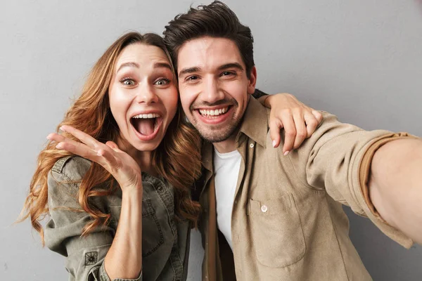 Retrato Jovem Casal Animado Abraçando Enquanto Toma Uma Selfie Isolada — Fotografia de Stock