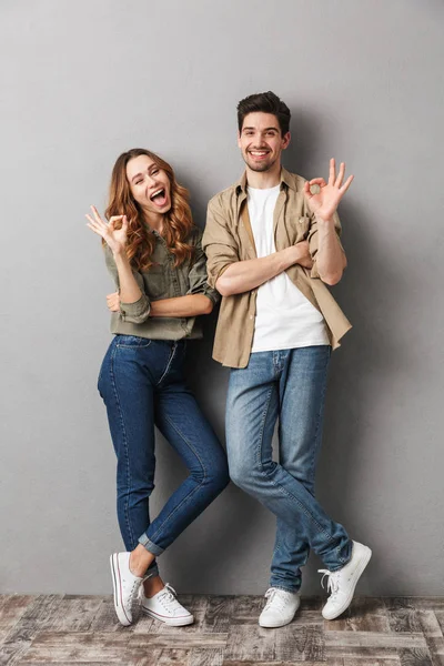 Retrato Larga Duración Una Alegre Pareja Joven Pie Juntos Mostrando — Foto de Stock