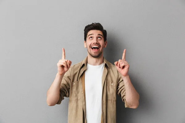 Portrait Cheerful Young Casual Man Pointing Copy Space Isolated Gray — Stock Photo, Image