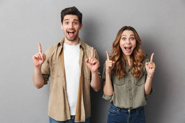 Portrait Cheerful Young Couple Standing Together Isolated Gray Background Pointing — Stock Photo, Image