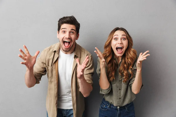 Portrait Excited Young Couple Standing Together Isolated Gray Background Screaming — Stock Photo, Image