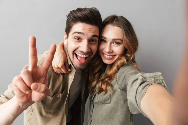 Portrait Happy Young Couple Hugging While Taking Selfie Isolated Gray — Stock Photo, Image