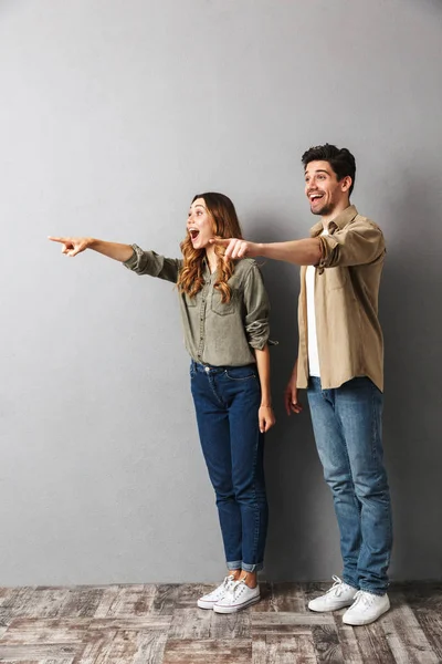 Retrato Comprimento Total Jovem Casal Chocado Apontando Para Longe Espaço — Fotografia de Stock