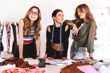 Üç güzel genç kadın giyim tasarımcıları atelier birlikte çalışma