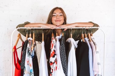 Giysi raf kapalı kalan genç ve güzel kadın giyim tasarımcısı