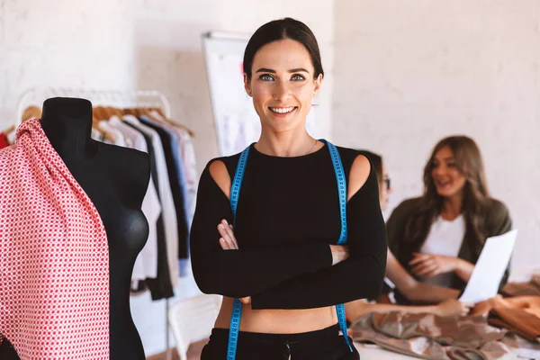 Joven Diseñadora Ropa Alegre Estudio Atelier Trabajando Con Colegas Fondo — Foto de Stock