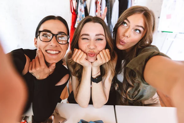 Tres Hermosas Jóvenes Diseñadoras Ropa Trabajando Juntas Taller Sentadas Mesa — Foto de Stock