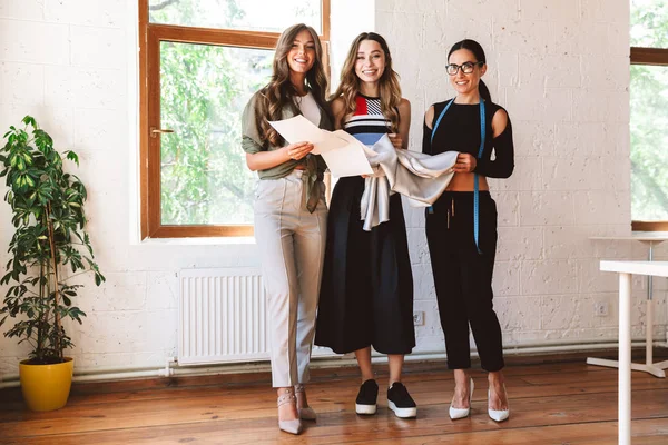 Tre Moderna Unga Kvinnor Kläder Formgivare Står Tillsammans Atelier — Stockfoto