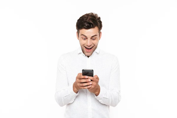 短い黒い髪のチャットや 白い背景で隔離のスマート フォンでテキスト メッセージを入力すると幸せな若い男 — ストック写真