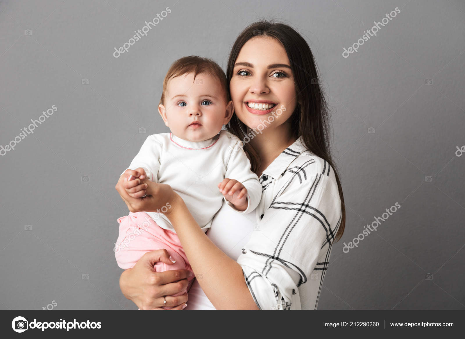 灰色の背景の上の彼女の小さな女の赤ちゃんを保持している若い母親を笑顔の肖像画 ストック写真 C Vadymvdrobot 灰色の背景の上の彼女の小さな女の赤ちゃんを保持している若い母親を笑顔の肖像画 ストック写真 C Vadymvdrobot