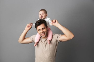Görüntü gri arka plan üzerinde izole boyun küçük çocuğunu taşıyan mutlu baba adam
