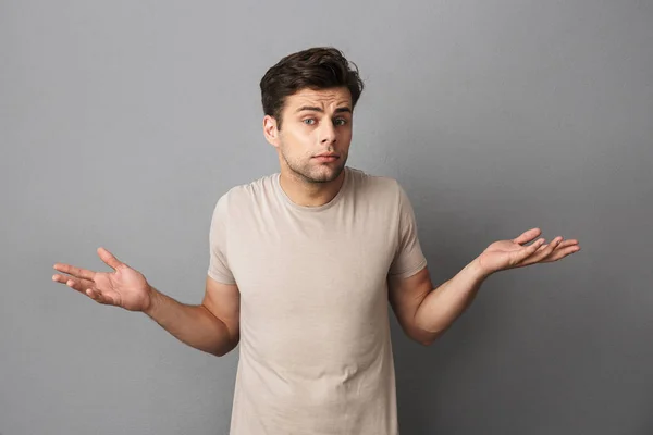 Retrato Joven Confuso Con Camiseta Aislada Sobre Fondo Gris Hombros —  Fotos de Stock