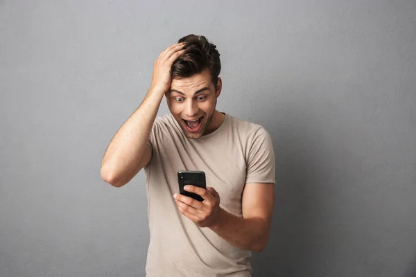 Καυκάσιος Νεαρός 20S Αρπάζοντας Κεφάλι Κρατώντας Smartphone Που Απομονώνονται Γκρίζο — Φωτογραφία Αρχείου