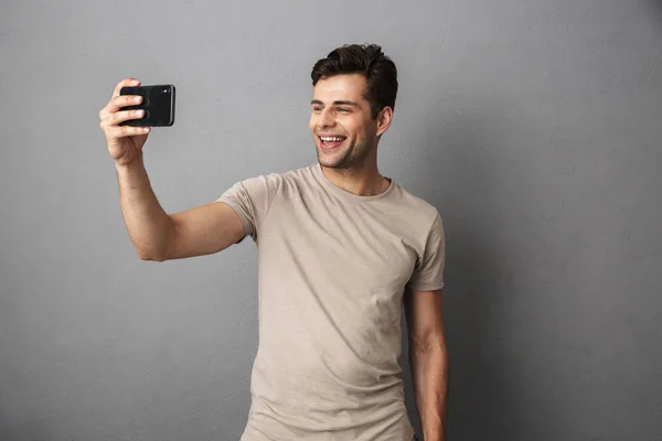 Retrato Joven Alegre Con Camiseta Aislada Sobre Fondo Gris Tomando — Foto de Stock