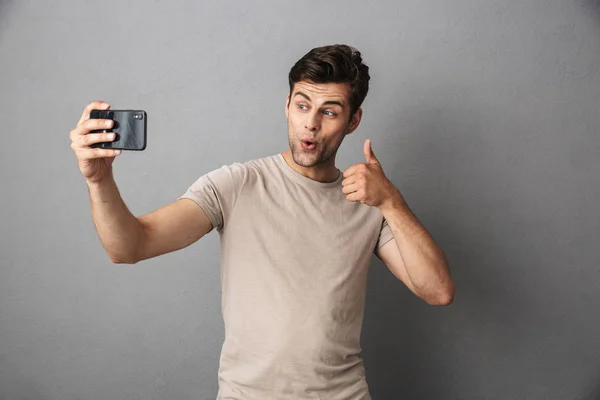 Retrato Joven Alegre Camiseta Aislado Sobre Fondo Gris Tomando Una — Foto de Stock