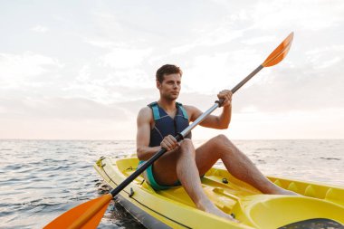 Yakışıklı delikanlı göl deniz tekne üzerinde kayak görüntüsünü.