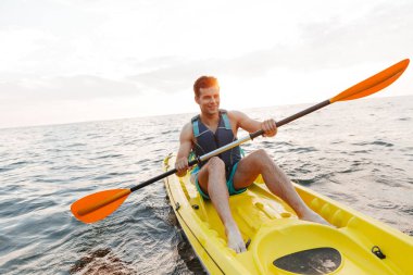 Yakışıklı delikanlı göl deniz tekne üzerinde kayak görüntüsünü.