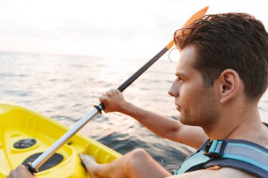 Yakışıklı delikanlı göl deniz tekne üzerinde kayak görüntüsünü.