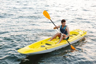 Yakışıklı delikanlı göl deniz tekne üzerinde kayak görüntüsünü.