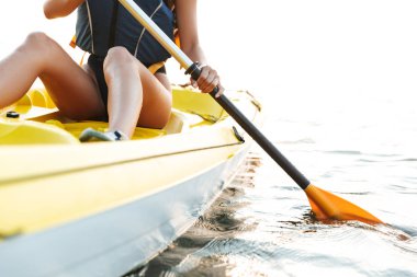 Genç kadının üzerinde botla göl denize Kayak fotoğrafını kırpılmış.