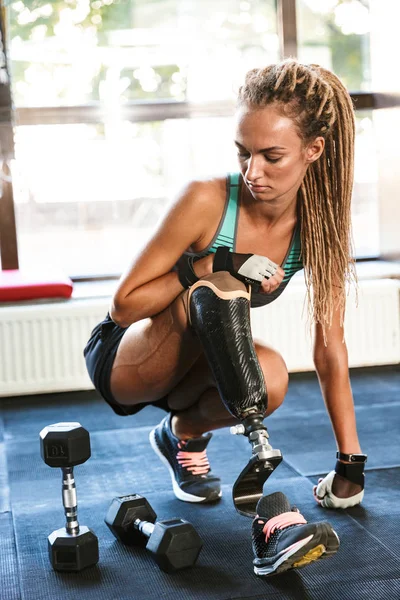 Image of strong disabled sports woman sitting in gym.