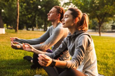 Görüntü konsantre fitness spor egzersizleri meditasyon park açık havada dost sevgi dolu çift.