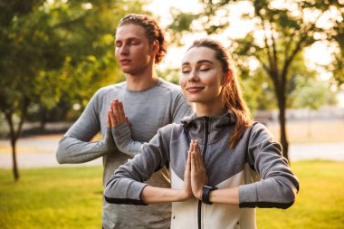 IMAG konsantre fitness spor egzersizleri meditasyon park açık havada dost sevgi dolu çift.
