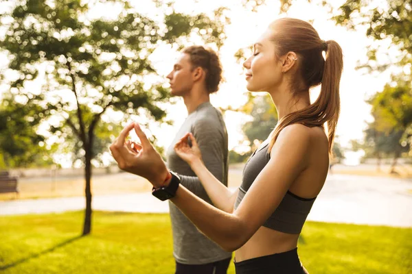 轻松运动情侣和女人的形象20S 在运动服握着手指一起冥想 而在绿色公园锻炼或做瑜伽 — 图库照片