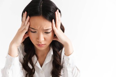 Masada oturan ve beyaz arka plan üzerinde izole ellerle baş kapma yorgun ya da üzgün Asya iş kadın 20'li yaşlarda giyen ofis giyim görüntü