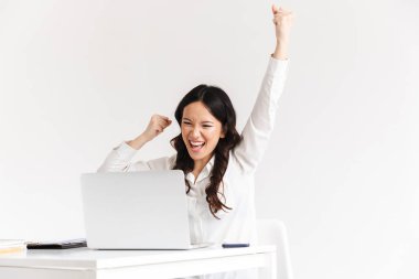 Mutlu Çin iş kadını ile çığlık uzun siyah saçlı fotoğrafı belgeler ve beyaz arka plan üzerinde izole laptop ile çalışırken silah kaldırdı