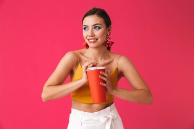 Gazlı İçecek pembe üzerinde izole tutan parlak makyajlı çekici genç kız