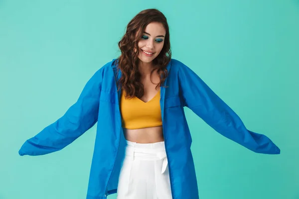 年轻有吸引力的女人的肖像20S 穿着雨衣或夹克看着在蓝色背景下隔离的相机 — 图库照片