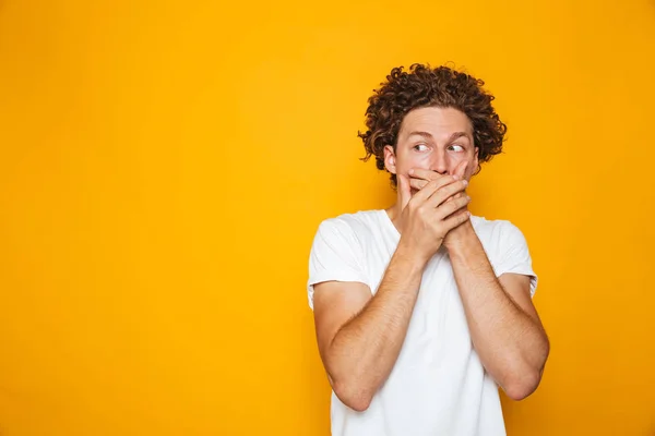 Portrait Shocked Curly Haired Man Covering Mouth Isolated Yellow Background — Stock Photo, Image