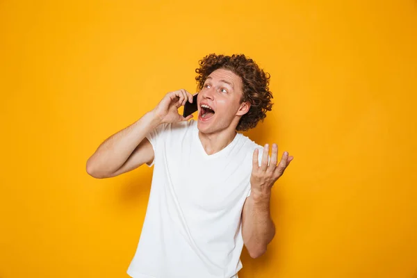 Photo Happy Young Guy Curly Hair Shouting Talking Smartphone Isolated — Stock Photo, Image