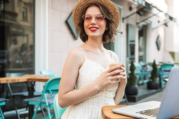 Mujer Agradable Vestido Sombrero Paja Beber Café Mientras Está Sentado —  Fotos de Stock