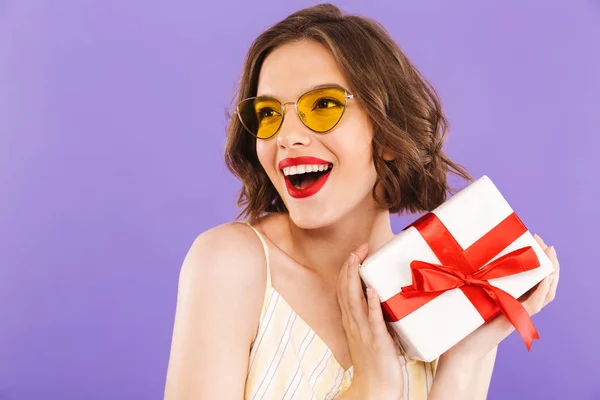 Portrait Laughing Young Woman Sunglasses Holding Present Box Violet Background — Stock Photo, Image