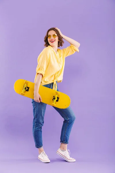 Портрет Щасливої Молодої Дівчини Тримає Скейтборд Виділяється Фіолетовому Фоні — стокове фото