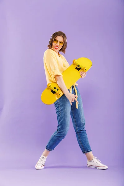 Full Längd Porträtt Glad Ung Flicka Hörlurar Holding Skateboard Ständiga — Stockfoto